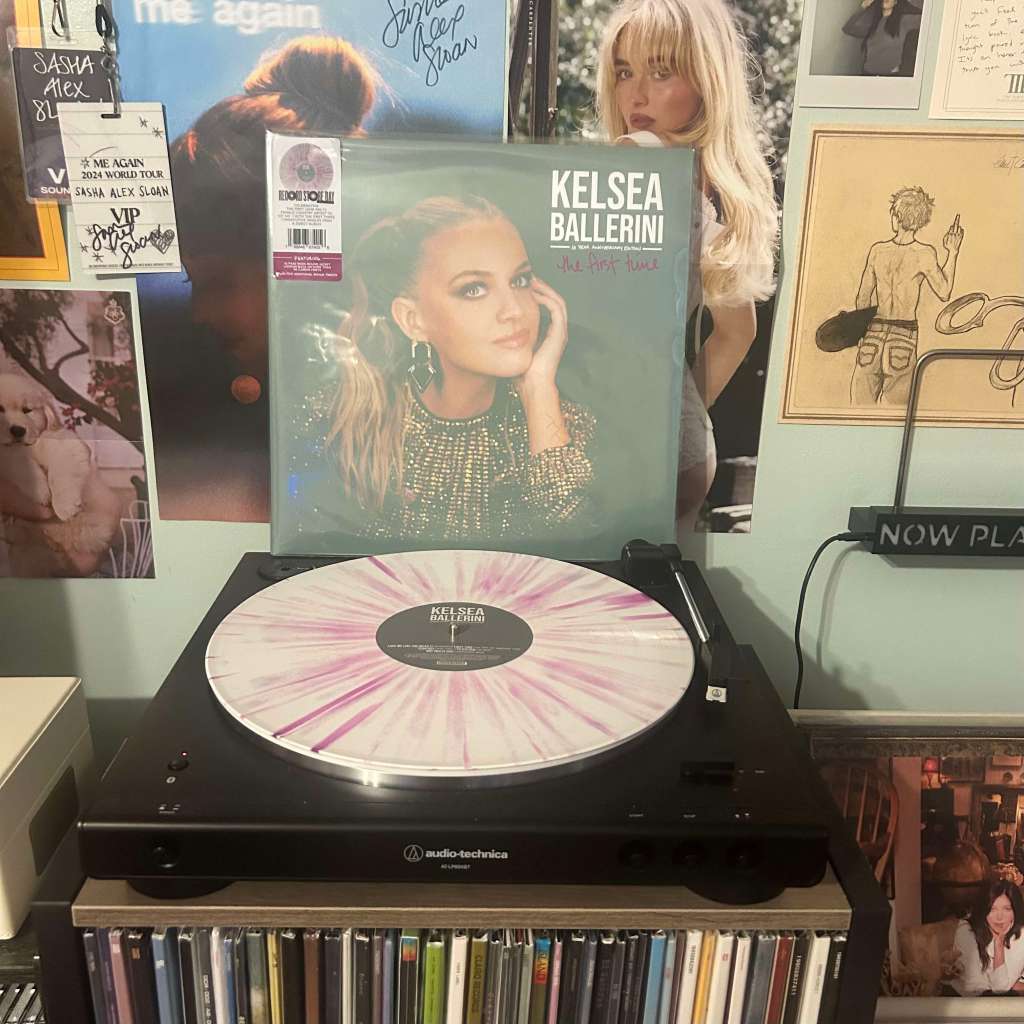 A pink-and-white splatter vinyl of Kelsea Ballerini – The First Time playing on an Audio-Technica LP60X, with the matching album sleeve propped up behind it.