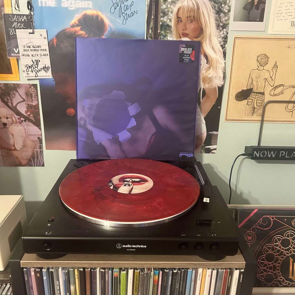 A deep red marbled vinyl playing on an Audio-Technica LP60X, with the album cover showing abstract blue art behind it.