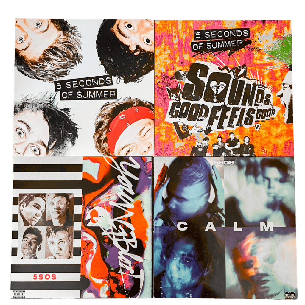 Four vinyl records from 5 Seconds of Summer: debut album 5 Seconds of Summer with band members’ faces on a white background, Sounds Good Feels Good with graffiti-style artwork, Youngblood with a colorful abstract cover and band portrait, and CALM with blurred portraits of the band in blue tones.