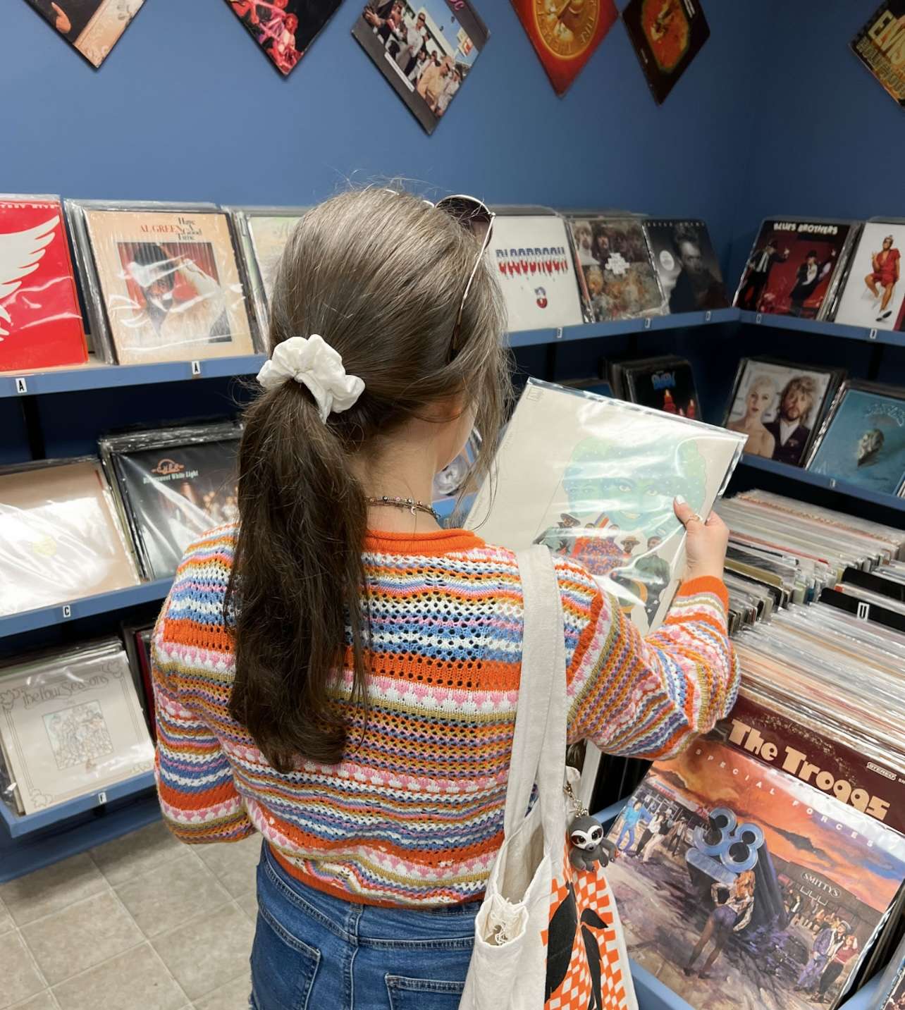 Young woman browsing through vinyl records in a record store