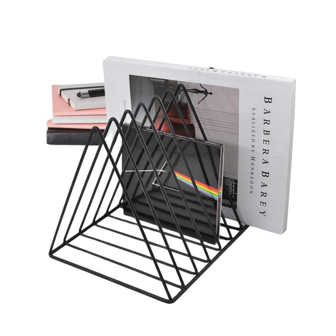 Black metal 9-slot tabletop record holder with triangular dividers, shown holding LP jackets and books; a prism-and-rainbow album cover is visible in front.