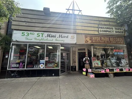 Street view of Hyde Park Records in Chicago, with vinyl bins displayed outside and signage advertising records, tapes, and CDs.