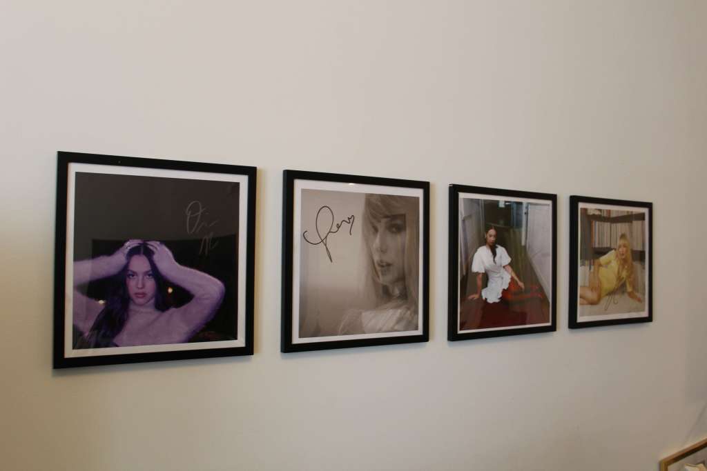 Minimalist wooden turntable with a clean white vinyl record platter sitting on a wooden desk.