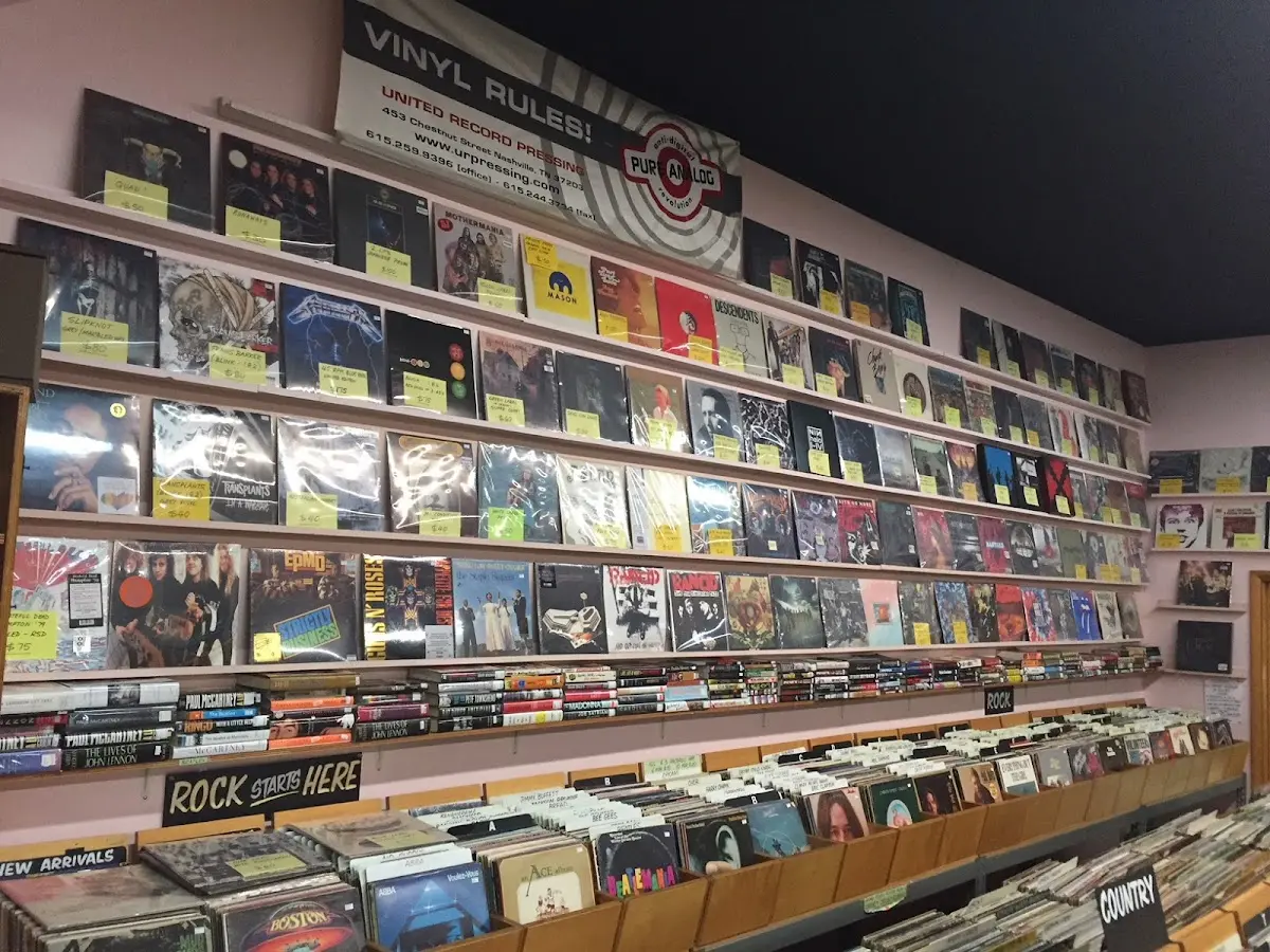 Interior of Phonoluxe Records with rows of vinyl organized by genre under a banner reading ‘Vinyl Rules!’ and album covers displayed on the wall