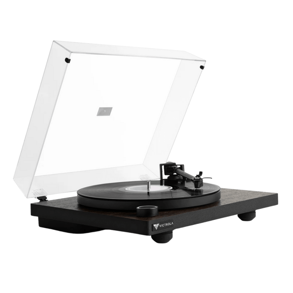 Victrola Premiere T1 turntable with a clear dust cover open, showing a vinyl record on the metal platter. The wooden plinth and minimalist black design highlight its modern yet classic look.