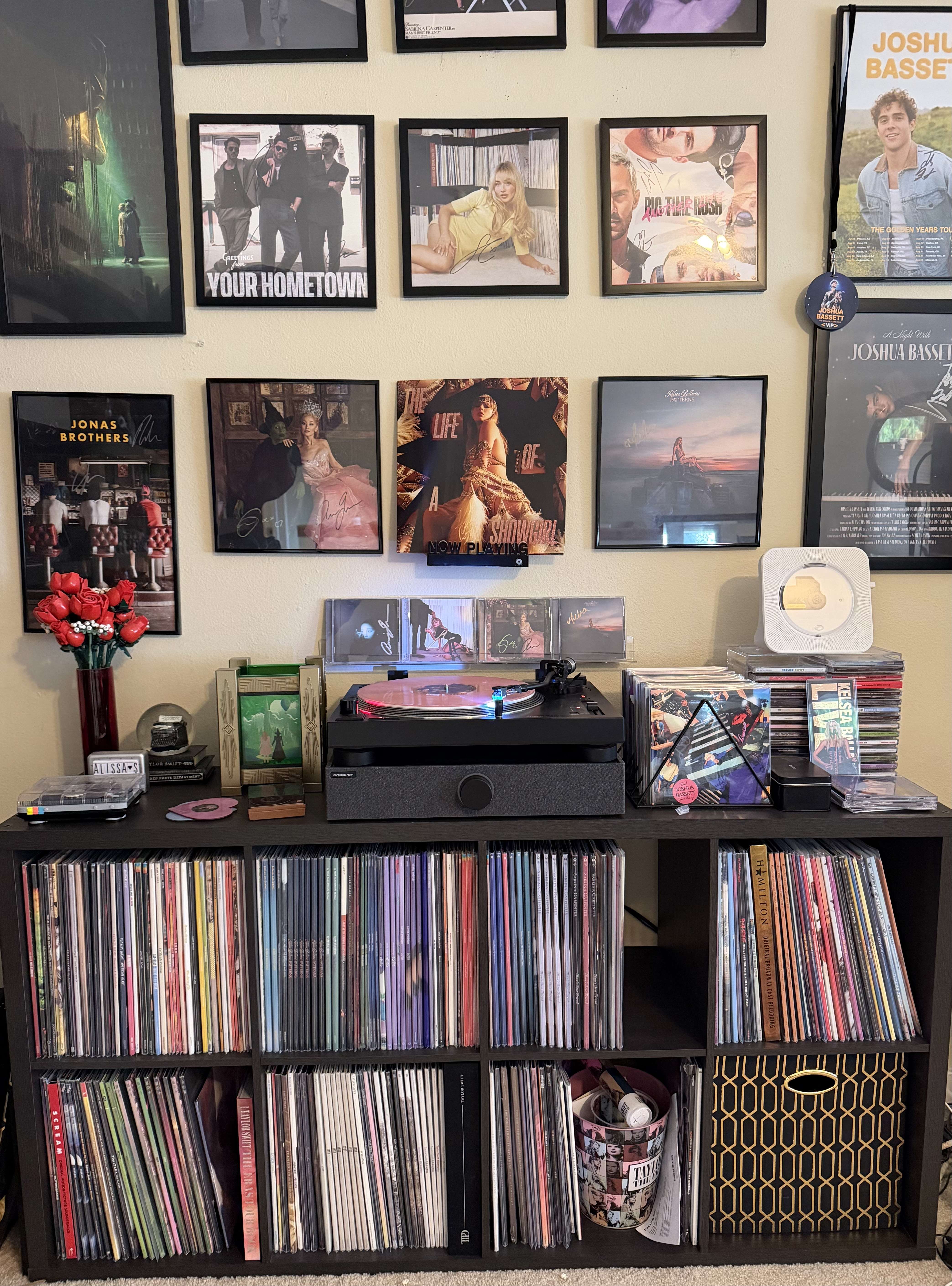 Wide view of Alissa’s listening wall with framed albums, a turntable on a black console, CDs, decor, and cubby shelves packed with vinyl.