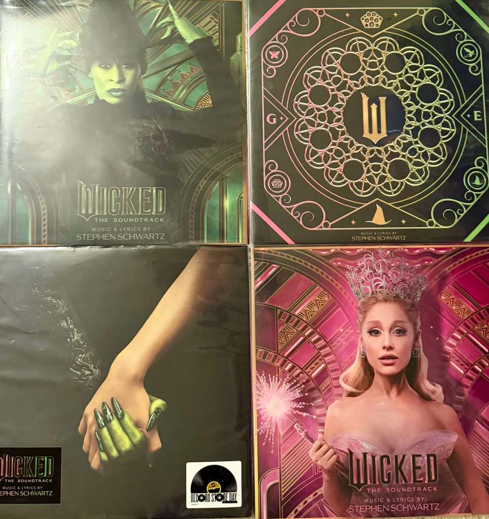 Four “Wicked” soundtrack vinyl records arranged in a grid — featuring cover art of Elphaba in green, Glinda in pink, a Record Store Day exclusive with intertwined hands, and a geometric gold-and-green design with the Wicked logo.