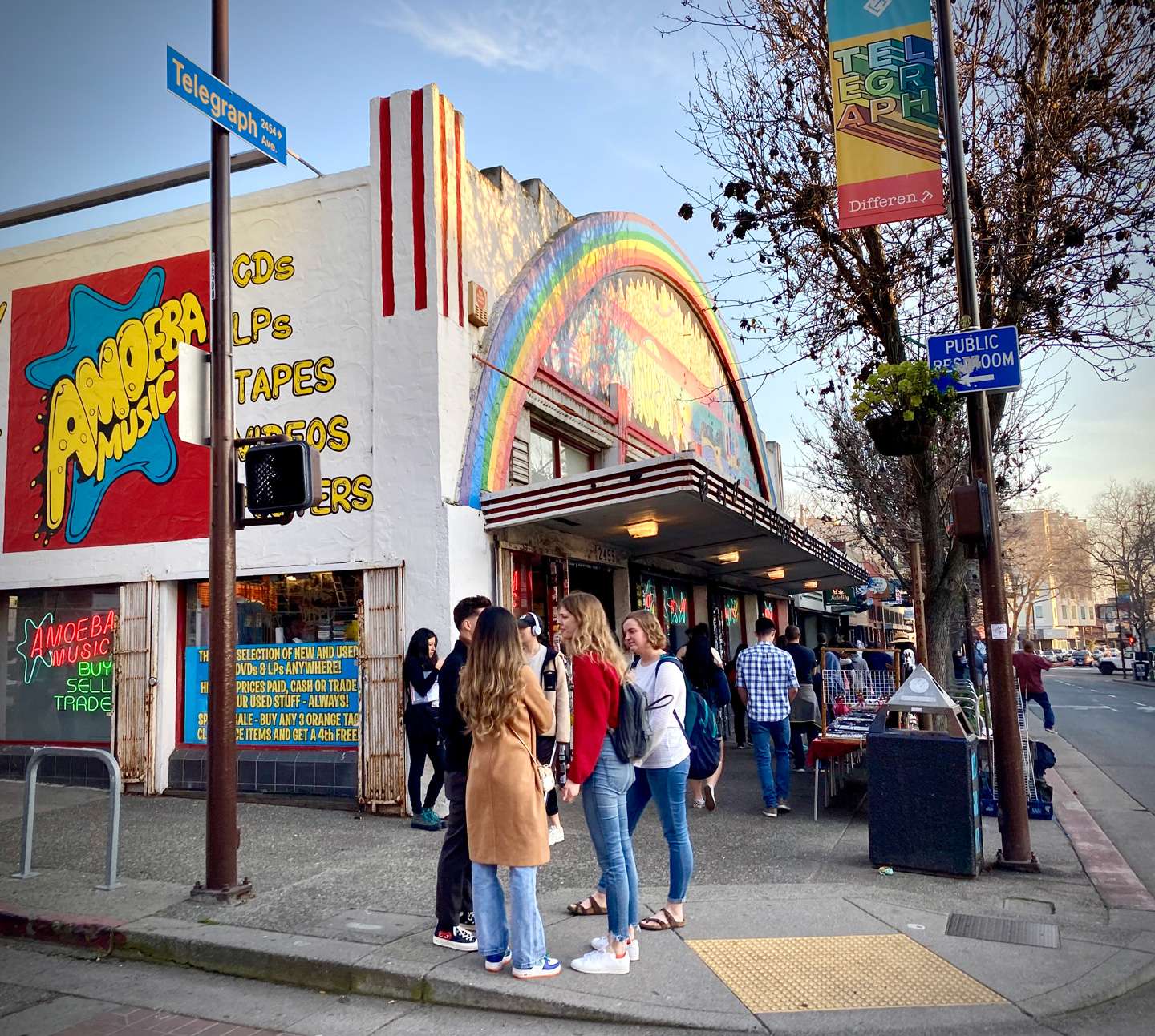 exterior on Telegraph Ave with rainbow arch facade and crowd of shoppers.
