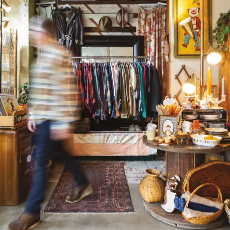Interior of Beacon Sound in Portland, Oregon, featuring racks of vintage clothing, art, and analog gear. The cozy, eclectic setup reflects the shop’s mix of records, design objects, and creative community energy.