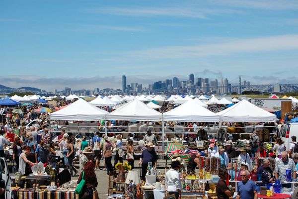 outdoor vinyl and vintage stalls with white tents and San Francisco skyline in background.