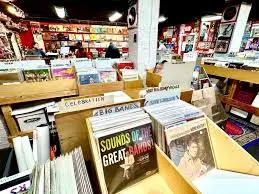 Spacious store with wooden bins and bold genre dividers; classic rock and jazz titles up front.