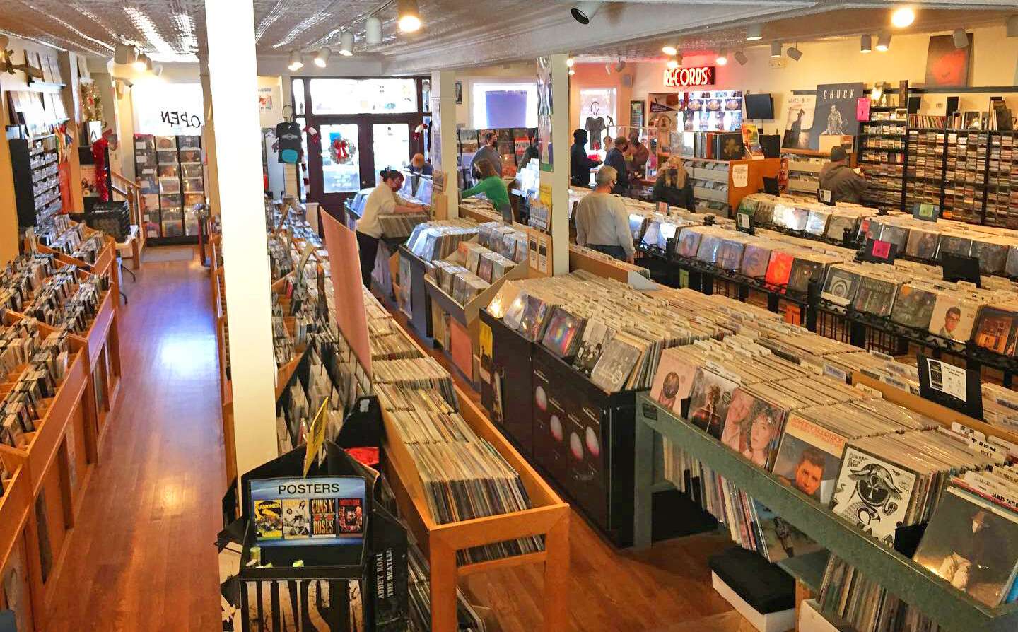 Interior of Euclid Records in New Orleans, filled with rows of vinyl bins, wooden floors, and bright lighting as customers browse through albums.