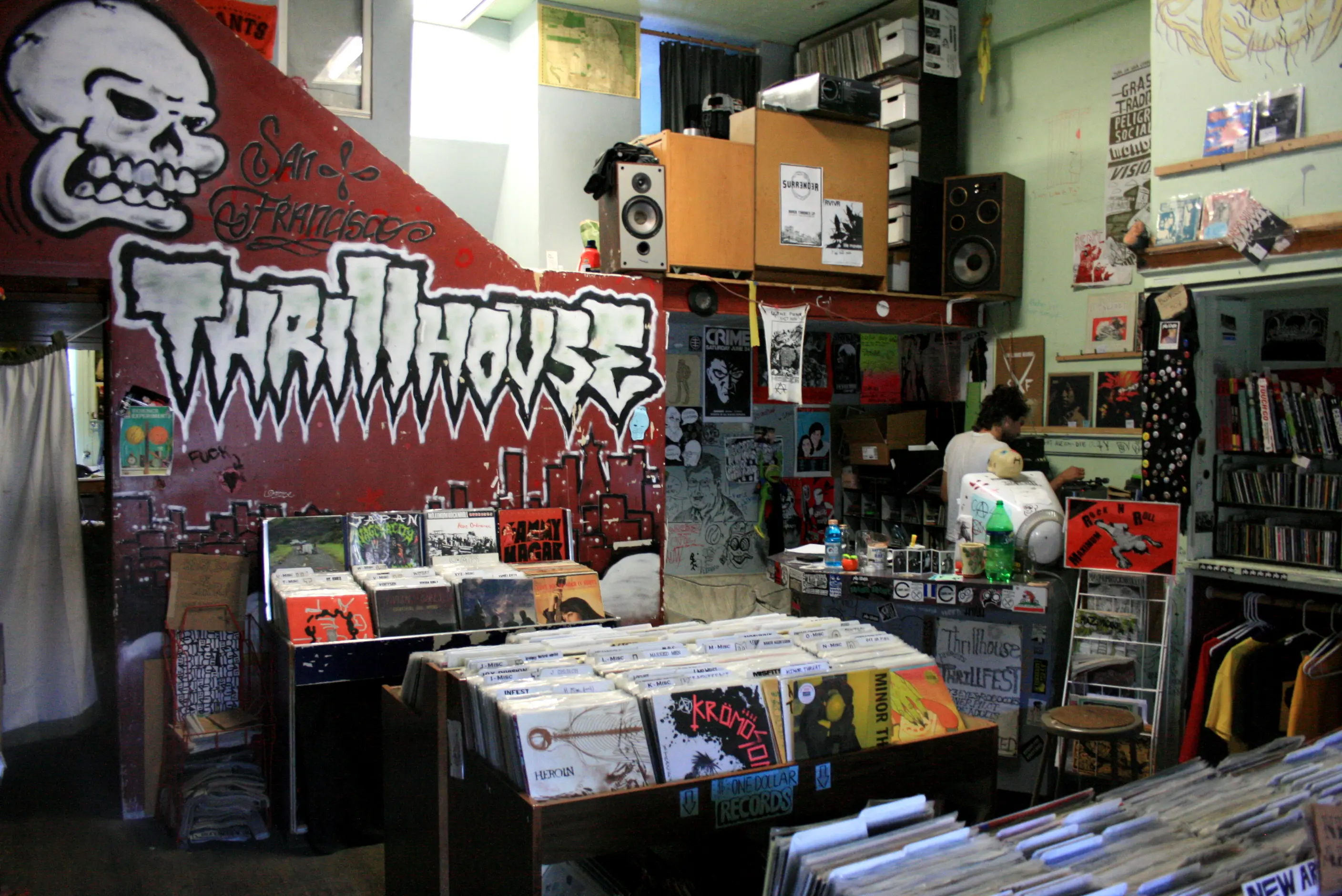 Punk-centric SF shop with graffiti “Thrillhouse” mural, flyers and posters, and bins of used punk/hardcore LPs.